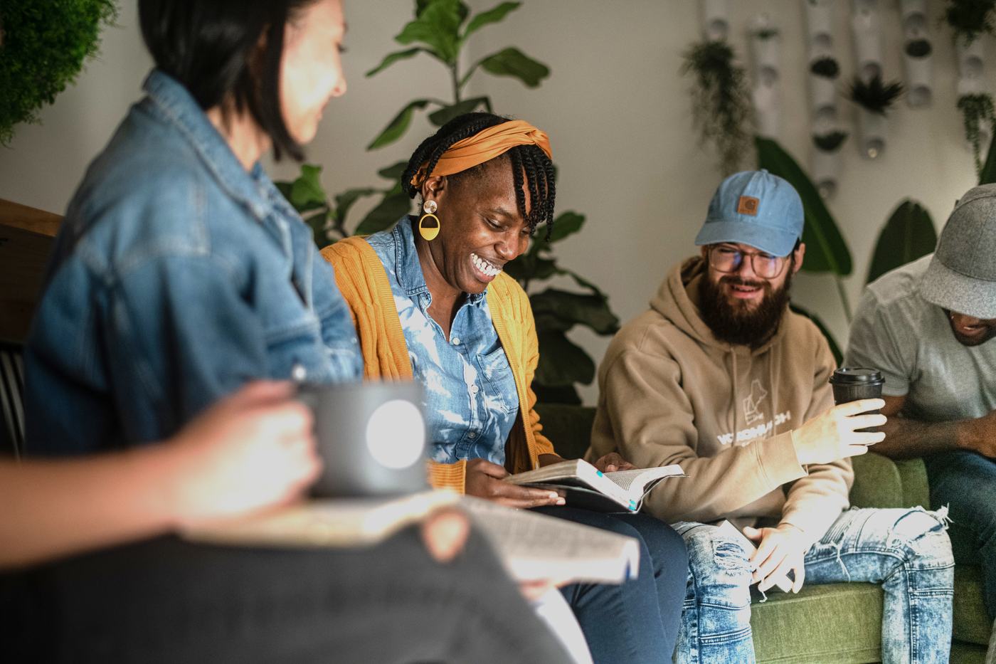 Members of a Vox community group laughing together over open Bibles and coffee